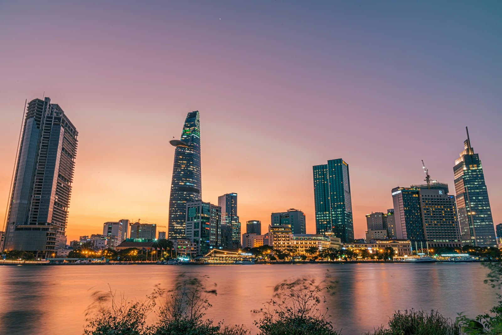 Ho Chi Minh City skyline and Bitexco Financial Tower at dusk over the Saigon River