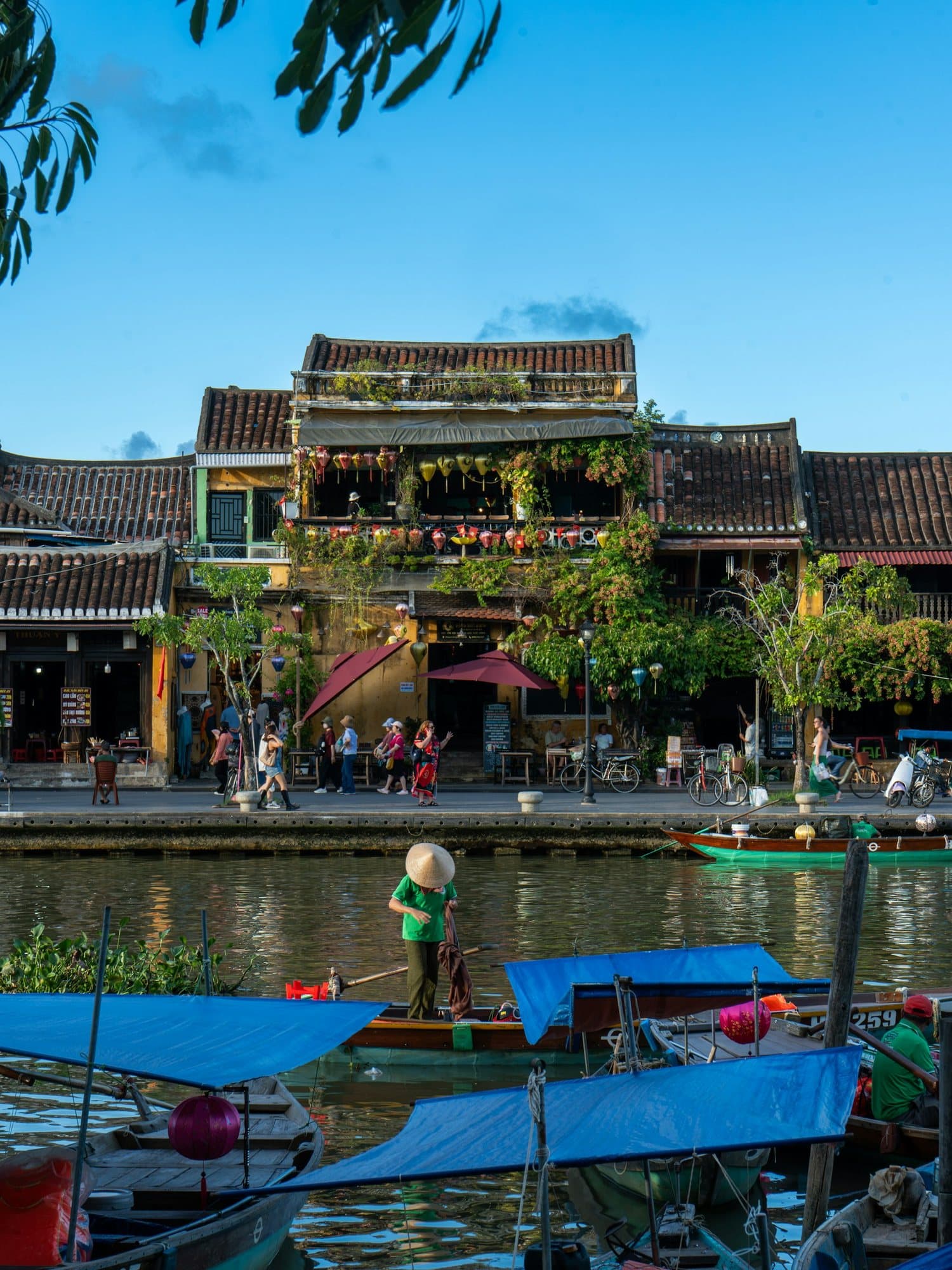 Boats on the Thu Bon River with Hoi An yellow shophouses across the water